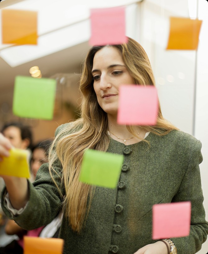 Team member reviewing ideas on sticky notes in the studio